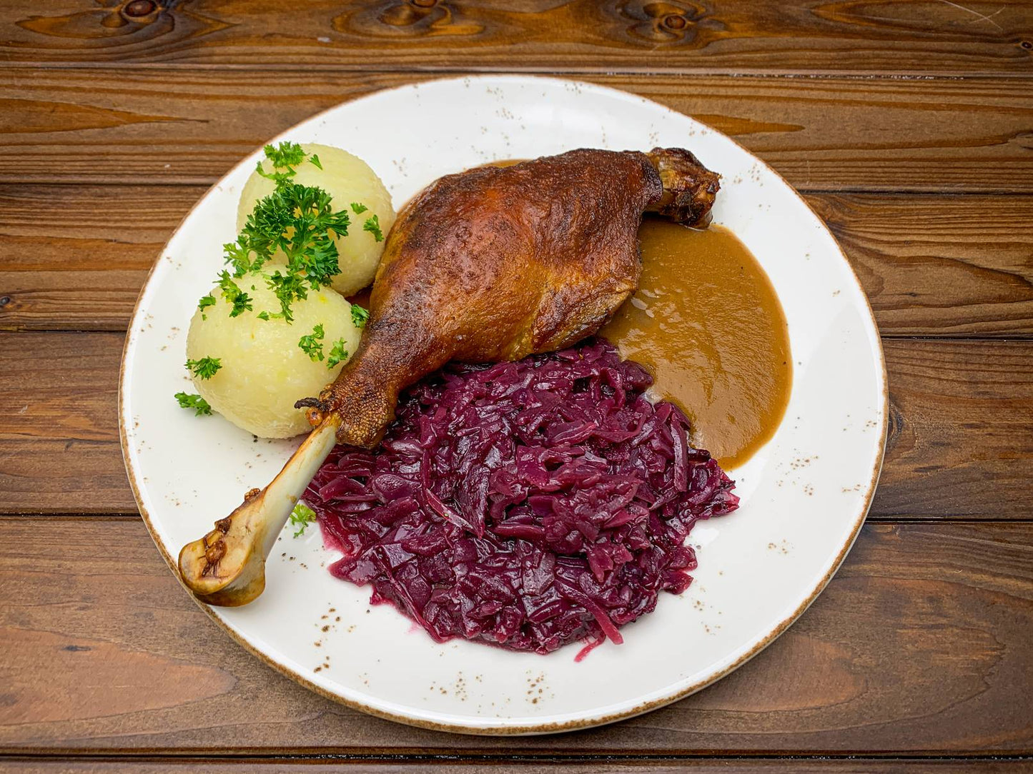 Rotkohl/Blaukraut mit Gänsekeule und Beilage auf Teller