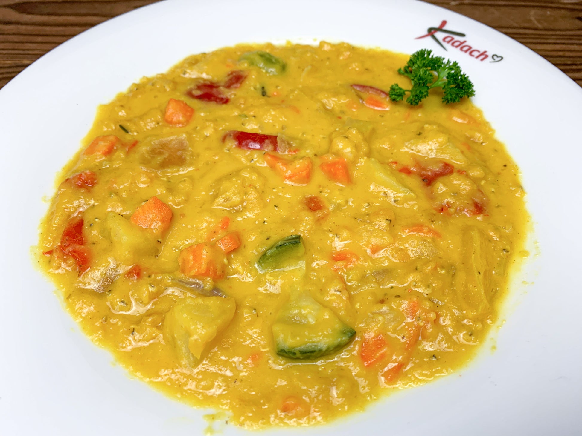 Rote Linsen-Currysuppe auf Suppenteller, vegetarisch